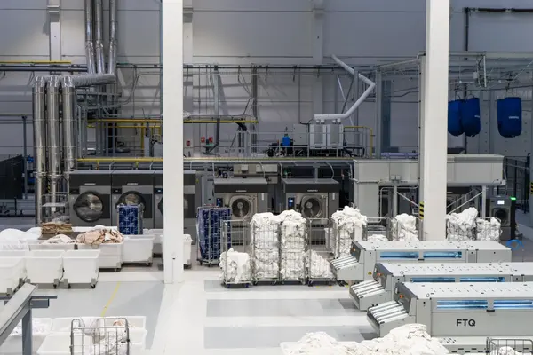 High-capacity resort industrial laundry with water-efficient tunnel washing line