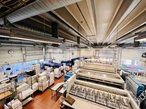 Inline process-water recycling installation at a commercial laundry