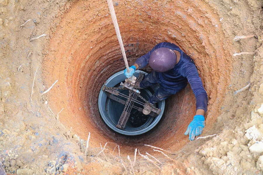 Operario inspeccionando un pozo de captación