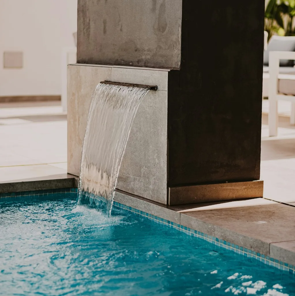 Piscina de hotel y zonas verdes ajardinadas